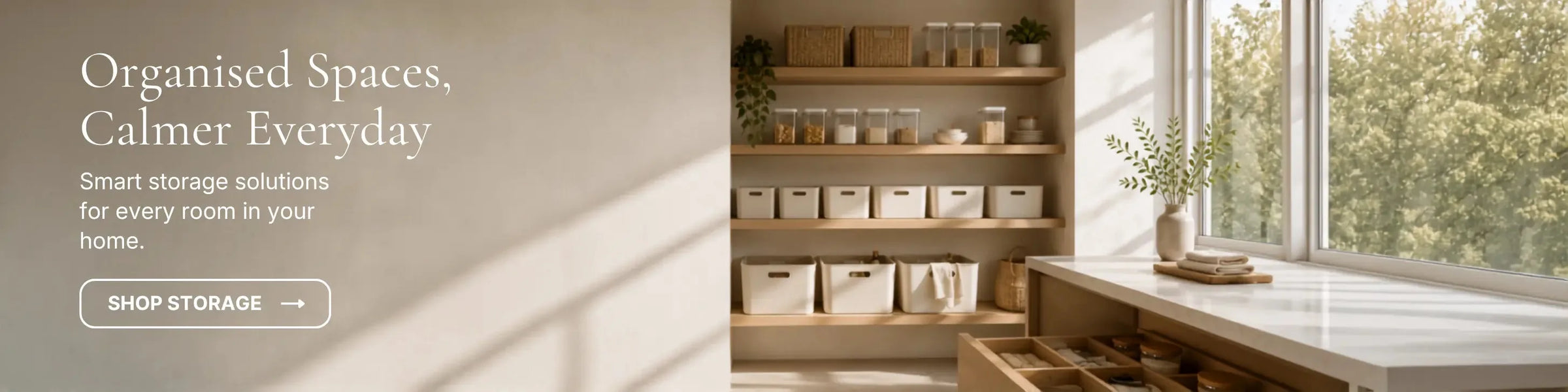 Organised pantry shelving with white storage bins, glass jars, and cutlery drawer under warm natural light.